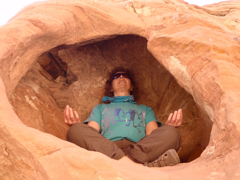 Jenny meditating in Easy Pose (Sukasana) in a red sandstone alcove in Valley of Fire State Park, Nevada (Photo by Ian Hatter).