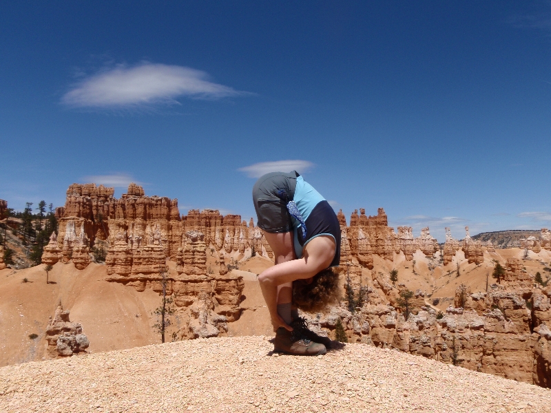 Jenny in Standing Forward Bend Pose (Uttanasana), feet hip width apart and hands on ankles variation, Bryce Canyon National Park, Utah. (Photo by Ian Hatter)