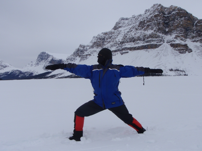 Jenny in Warrior Two Pose (Virabhadrasana II) on a snow and ice covered Bow Lake, headwaters of the Bow River, Banff National Park.  It was minus 27 degrees Celcius when this picture was taken, proving a dedicated yogi can still do outdoor yoga even during a Canadian winter (Photo by Ian Hatter).