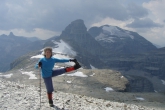 Jenny in Standing Extended Hand to Big Toe Pose (Utthita Hasta Padangustasana) with a little help from a hiking pole atop Royal Ridge near spectacular Talus Lodge, B.C. (Photo by Ian Hatter)